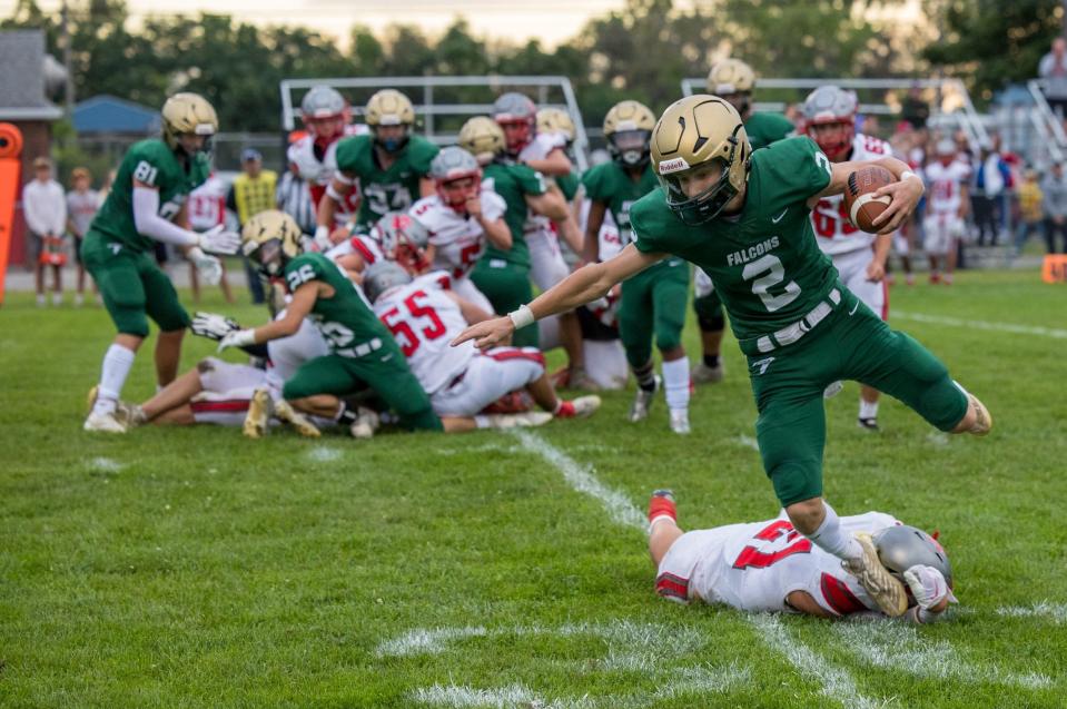 Ian Foster of St. Mary Catholic Central is tripped up by Grosse Ile's Matthew Pizzo. The Falcons lost to Grosse Ile 21-20 in overtime.