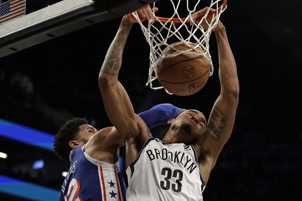 Brooklyn Nets center Nic Claxton (33) dunks in front of Philadelphia 76ers forward Tobias Harris during the first half of an NBA basketball game Tuesday, March 5, 2024, in New York. (AP Photo/Adam Hunger)