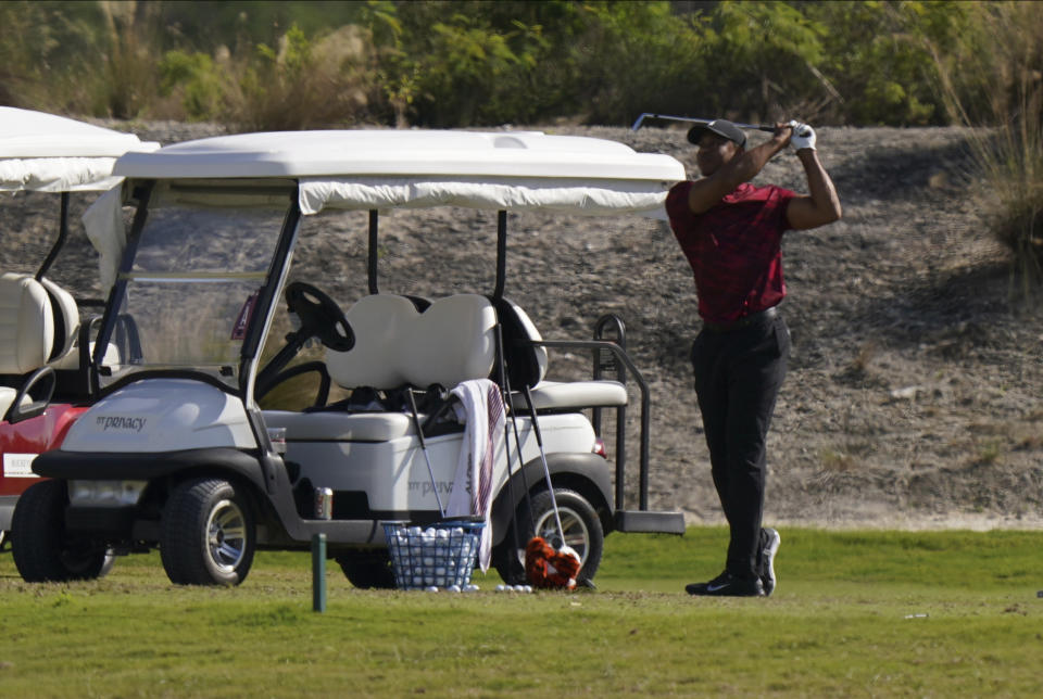 Tiger Woods watches his shot during a training session at the Albany Golf Club, in New Providence, Bahamas, Sunday, Dec. 5, 2021.(AP Photo/Fernando Llano)