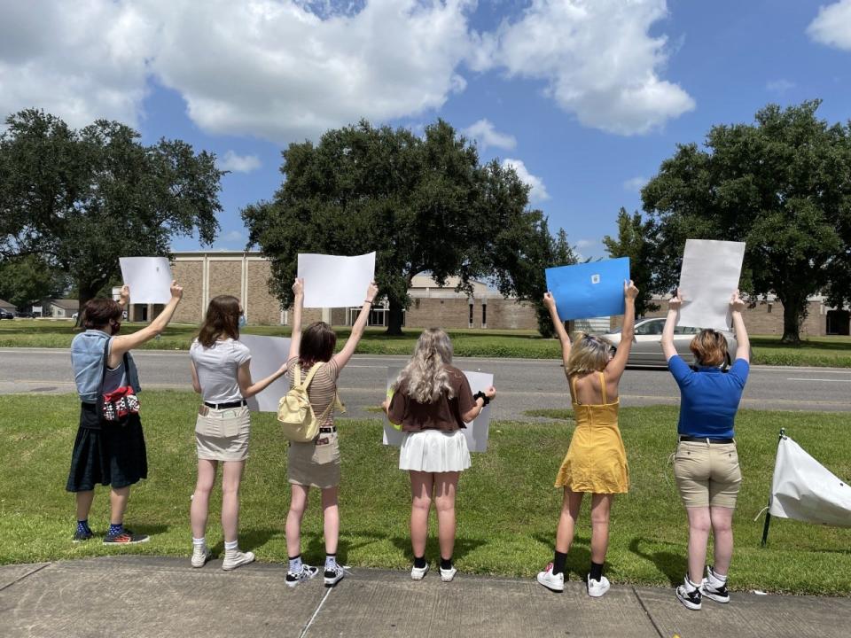 Protesters gather across from H.L. Bourgeois High School Friday to bring awareness to the school's dress code policy which they argue is discriminatory.