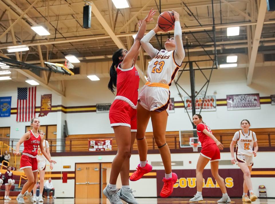 Bloomington North’s Mia Robbennolt (23) attempts a shot over Center Grove’s Aubrie Booker (3) during their game at North on Friday, Dec. 22, 2023.