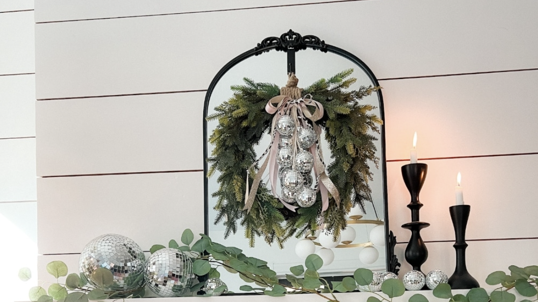 a fireplace with a discoball wreath hanging from it