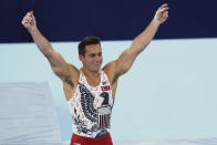 FILE - In this July 24, 2021, file photo, Samuel Mikulak, of the United States, celebrates his performance on the parallel bars during the men's artistic gymnastic qualifications at the 2020 Summer Olympics in Tokyo. In arenas across Tokyo, athletes accustomed to feeding off the deafening roar of the crowd are searching for new ways to feel Olympic enthusiasm. (AP Photo/Natacha Pisarenko, File)