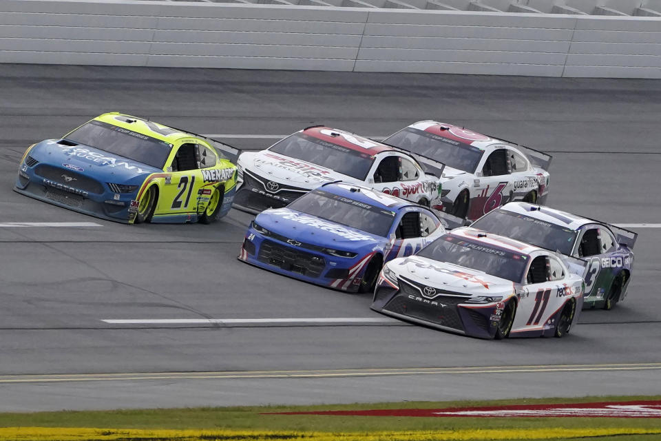 Denny Hamlin (11) races William Byron (24) and Matt DiBenedetto (21) to the finish line during the YellaWood 500 NASCAR auto race at Talladega Superspeedway, Sunday, Oct. 4, 2020, in Talladega, Ala. Hamlin won. (AP Photo/John Bazemore)