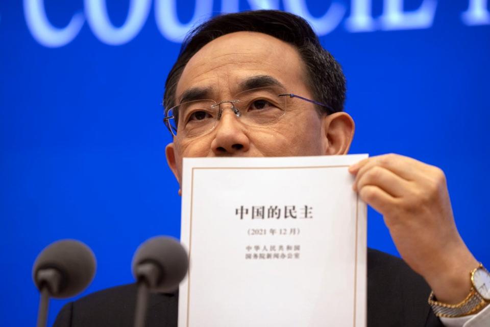 Xu Lin, vice minister of the publicity department of the central committee of China’s Communist Party holds a copy of a government-produced report titled “Democracy that Works” in Beijing on Saturday (AP)