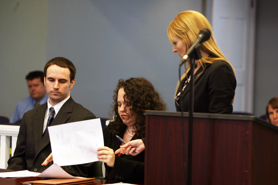 U.S. Army Pvt. Christopher Salmon, left, listens as his attorney Gabrielle Amber Pittman, center, and Assistant District Attorney Isabel Pauley go over a plea deal Thursday, April 3, 2014, in a Long County, Ga. courtroom. Salmon pleaded guilty to malice murder charges in the killing of former military colleague Michael Roark, and was sentenced to life in prison with no chance of parole. (AP Photo/Lewis Levine)