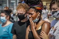A mourner cries as she visits a makeshift memorial for George Floyd on the corner of Chicago Avenue and East 38th Street, Sunday, May 31, 2020, in Minneapolis. Protests continued following the death of Floyd, who died after being restrained by Minneapolis police officers on May 25. (AP Photo/John Minchillo)