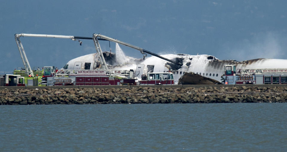 A fire truck sprays water on Asiana Flight 214 after it crashed at San Francisco International Airport on Saturday, July 6, 2013, in San Francisco. (AP Photo/Noah Berger)