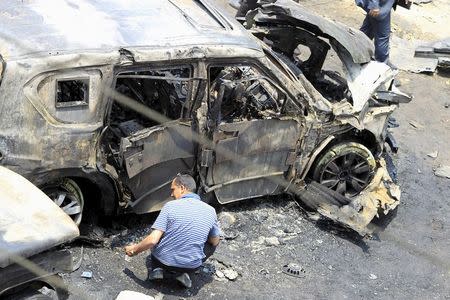 A crime scene investigator investigates the site of a car bomb attack on the convoy of Egyptian public prosecutor Hisham Barakat near his house at Heliopolis district in Cairo, June 29, 2015. REUTERS/Mohamed Abd El Ghany