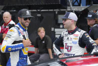 Chase Elliott, left, and William Byron talk during qualifications for a NASCAR Cup Series auto race at Michigan International Speedway in Brooklyn, Mich., Saturday, Aug. 5, 2023. (AP Photo/Paul Sancya)