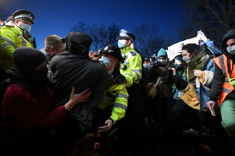 Police officers scuffle with people gathering at a band-stand where a planned vigil in honour of murder victim Sarah Everard was cancelled after police outlawed it due to Covid-19 restrictions, on Clapham Common, south London on March 13, 2021, - The police officer charged with murdering young Londoner, Sarah Everard, who disappeared while walking home from a friend's house, appeared in court on March 13, 2021, as organisers cancelled a vigil in her honour due to coronavirus restrictions. (Photo by JUSTIN TALLIS / AFP) (Photo by JUSTIN TALLIS/AFP via Getty Images)