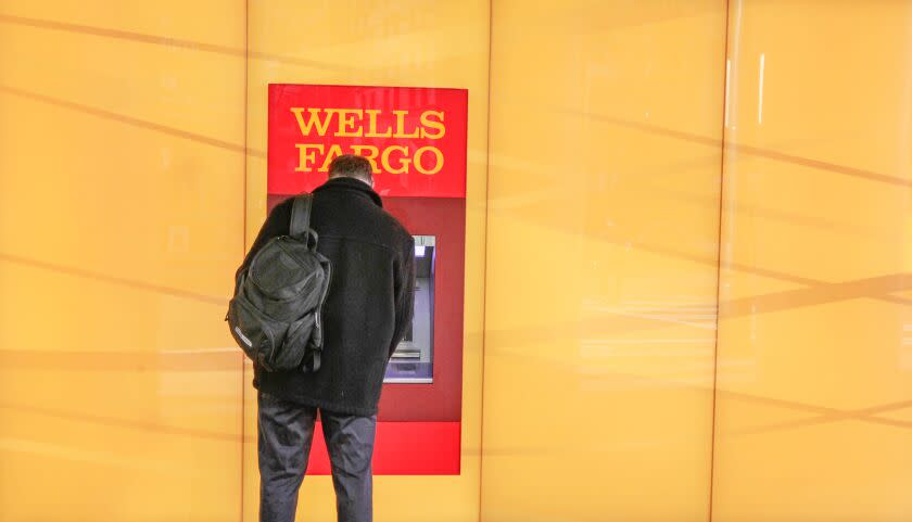 A customer uses an ATM outside a Wells Fargo branch in Charlotte, N.C. in 2012.