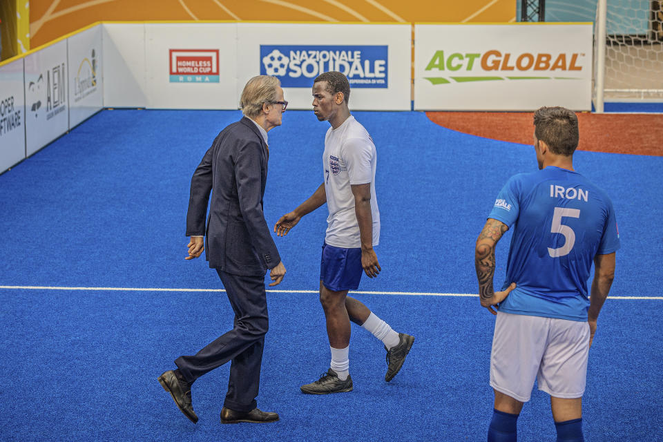 This image released by Netflix shows Micheal Ward, center, and Bill Nighy, left, in a scene from "The Beautiful Game." (Alfredo Falvo/Netflix via AP)