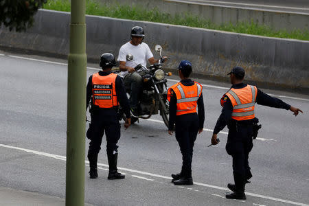 Police officers stand guard at a checkpoint during a shootout between security forces and rogue Venezuelan helicopter pilot Oscar Perez, in Caracas, Venezuela January 15, 2018. REUTERS/Marco Bello