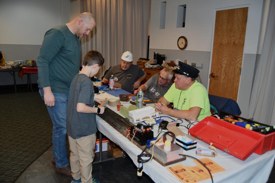Randy Ramsey, Joe Thorpe, Joe Matthews, seated from left, and A.J. Matthews and grandson Anthony Matthews, standing, all train hobbyists, participate in the Hayes Train Clinic on Saturday.