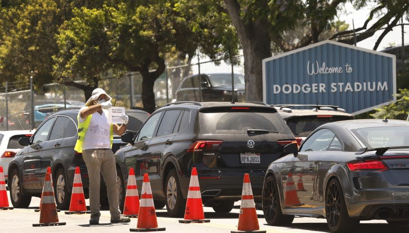 LOS ANGELES, CA - JULY 07: People confirm that drivers have a appointment for Coronavirus Covid-19 testing which has resumed at Dodger Stadium with a new drive-through testing site on Tuesday. Dodger Stadium on Tuesday, July 7, 2020 in Los Angeles, CA. (Al Seib / Los Angeles Times)