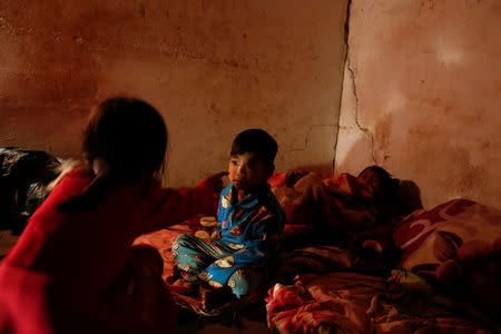 Refugee children who fled with their family fighting in neighbouring Myanmar pass the time in the house of a relative in the village of Baiyan near Nansan in the Yunan province, China, March 11, 2017. REUTERS/Thomas Peter