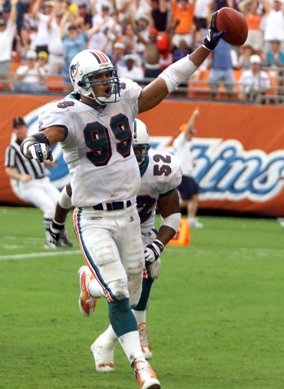 Jason Taylor scores a touchdown for the Dolphins after recovering a New England Patriots fumble by quarterback Tom Brady during a game in Miami, Oct. 7, 2001.