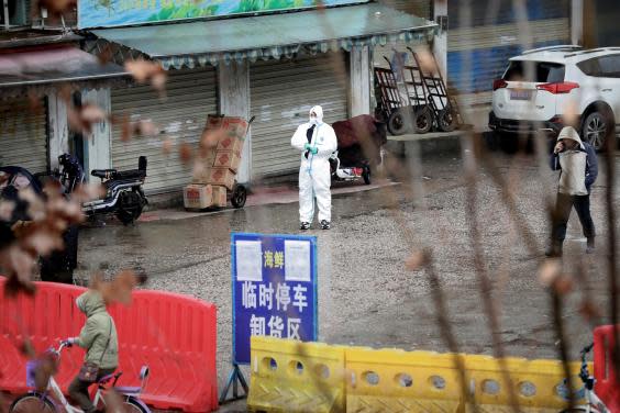 A health worker in a protective suit is seen at the closed seafood market in Wuhan (Reuters)