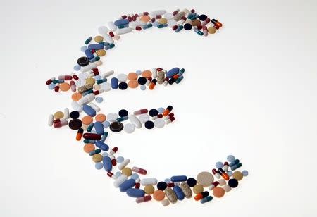 Pharmaceutical tablets and capsules are arranged in the shape of a Euro currency sign on a table in this picture illustration, August 20, 2014. REUTERS/Srdjan Zivulovic/Illustration/File Photo