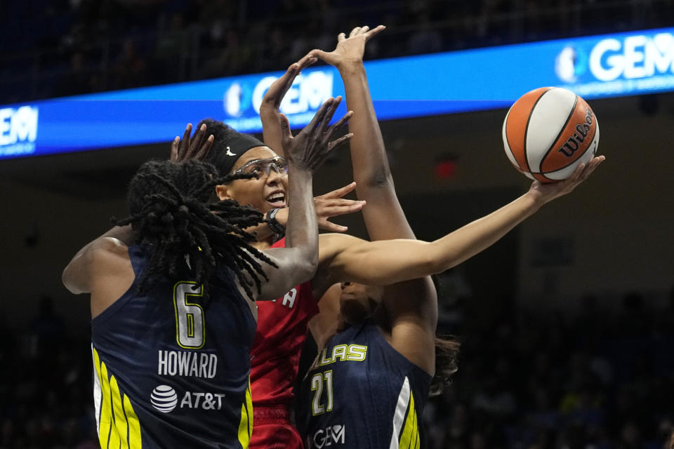 Atlanta Dream guard Allisha Gray, center, struggles to take a shot between Dallas Wings' Natasha Howard (6) and Kalani Brown (21) in the first half of Game 2 of a first-round WNBA basketball playoff series, Tuesday, Sept. 19, 2023, in Arlington, Texas. (AP Photo/Tony Gutierrez)