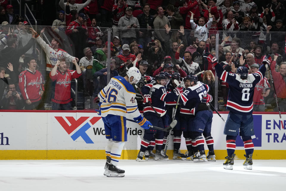 Washington Capitals left wing Alex Ovechkin (8) skates in to celebrate teammate Tom Wilson (43) third-period goal to tie the NHL hockey game as Buffalo Sabres defenseman Ilya Lyubushkin (46) skates past, Wednesday, March 15, 2023, in Washington. The Capitals won 5-4 in a shootout. (AP Photo/Carolyn Kaster)