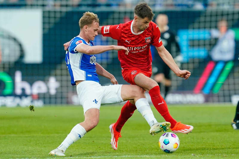 Darmstadt's Oscar Vilhelmsson (L) and Heidenheim's Marvin Pieringer battle for the ball during the German Bundesliga soccer match between SV Darmstadt 98 and 1. FC Heidenheim at Merck-Stadion am Boellenfalltor. Uwe Anspach/dpa