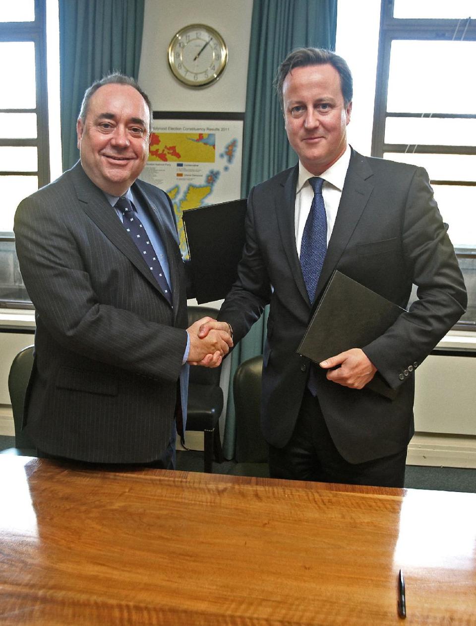 Britain's Prime Minister David Cameron, right, and Scotland's First Minister Alex Salmond, shake hands after signing a referendum agreement during a meeting at St Andrews House in Edinburgh, Monday, Oct. 15, 2012. Cameron met with the leader of Scotland's separatist administration Monday to sign a deal on a referendum that could break up the United Kingdom. Officials from London and Edinburgh have been meeting for weeks to hammer out details of a vote on Scottish independence. Sticking points included the date and the wording of the question. (AP Photo/Gordon Terris, Pool)