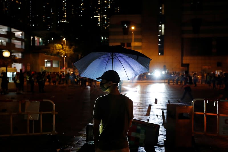An anti-government protester holds an umbrella during a protest following 22 year-old University student's fall and who was critically injured last weekend, in Tseung Kwan O, Hong Kong