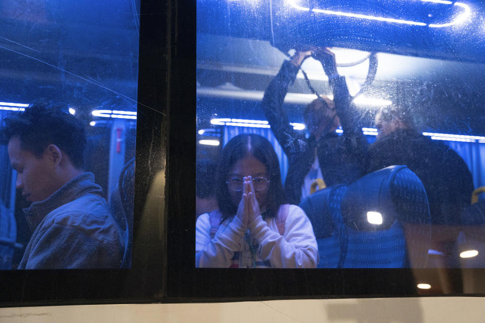 Thai nationals gesture from a bus as they leave the Shamir Hospital in Ramle, Israel, Wednesday, Nov. 29, 2023, on their way back to Thailand, after being released from Hamas custody. International mediators on Wednesday worked to extend the truce in Gaza, encouraging Hamas militants to keep freeing hostages in exchange for the release of Palestinian prisoners and further relief from Israel's air and ground offensive.(AP Photo/Maya Levin)