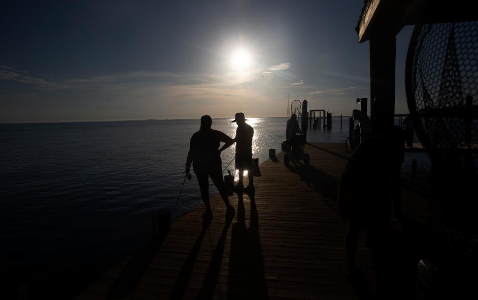 Naples residents, Edgar and Jessica Florian fish on Bokeelia Fishing Pier on the north end of Pine Island on Monday, July 31, 2023. The pier opened Monday after it was closed due to Hurricane Ian crushing Southwest Florida. The couple have been fishing on the pier for 20 years and say its one of their favorite places.