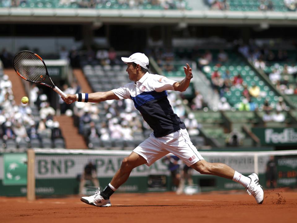 Kei Nishikori of Japan plays a shot to Thomaz Bellucci of Brazil during their men's singles match at the French Open tennis tournament at the Roland Garros stadium in Paris