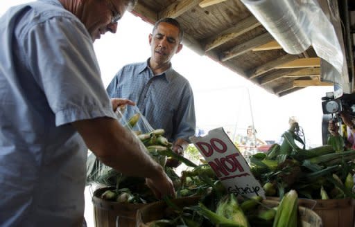 US President Barack Obama (C) buys a dozen ears of corn at the Bergman Orchards Farm Market in Port Clinton, Ohio. Obama Thursday heralded his first re-election campaign bus tour with a new trade blast at China and fresh accusations his White House foe Mitt Romney helped send US jobs abroad