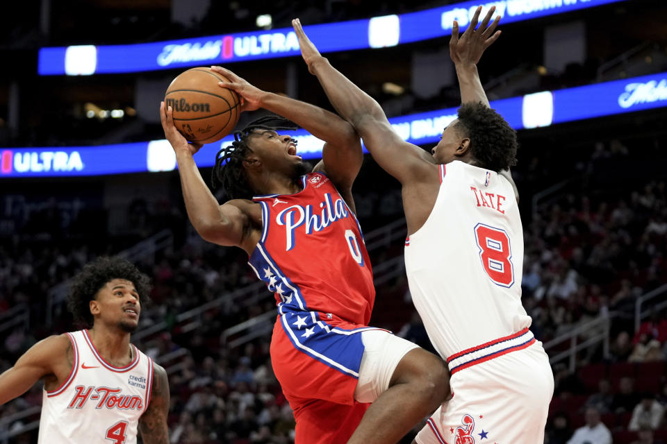 Philadelphia 76ers guard Tyrese Maxey (0) drives to the basket as Houston Rockets forward Jae'Sean Tate (8) defends during the first half of an NBA basketball game Friday, Dec. 29, 2023, in Houston. (AP Photo/Eric Christian Smith)