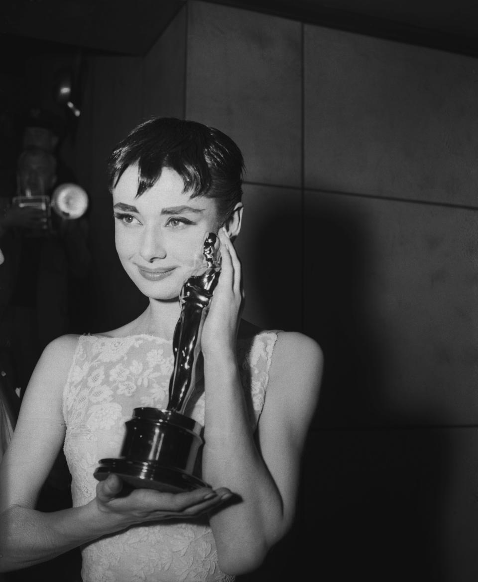 Audrey Hepburn holding the Academy Award for best actress in 