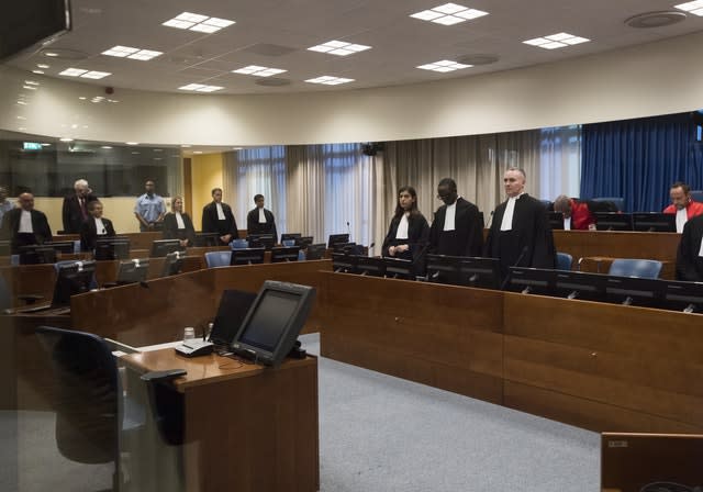 Former Bosnian Serb leader Radovan Karadzic, second left, rear, rises as judges enter the courtroom of the International Residual Mechanism for Criminal Tribunals in The Hague