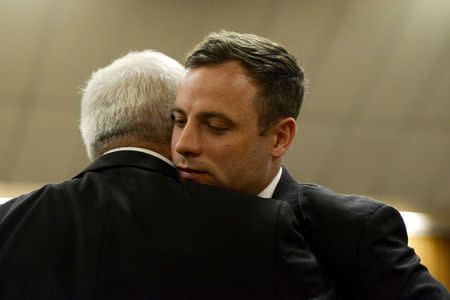 South African Olympic and Paralympic track star Oscar Pistorius hugs his father Henke Pistorius ahead of his sentencing at the North Gauteng High Court in Pretoria October 21, 2014. REUTERS/Herman Verwey/Pool