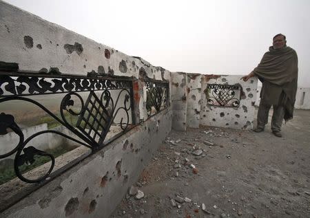 An Indian villager shows the boundary wall of his house, which locals said was damaged by firing from the Pakistan side of the border, at Bainglad village in Samba sector, south of Jammu January 6, 2015. REUTERS/Mukesh Gupta