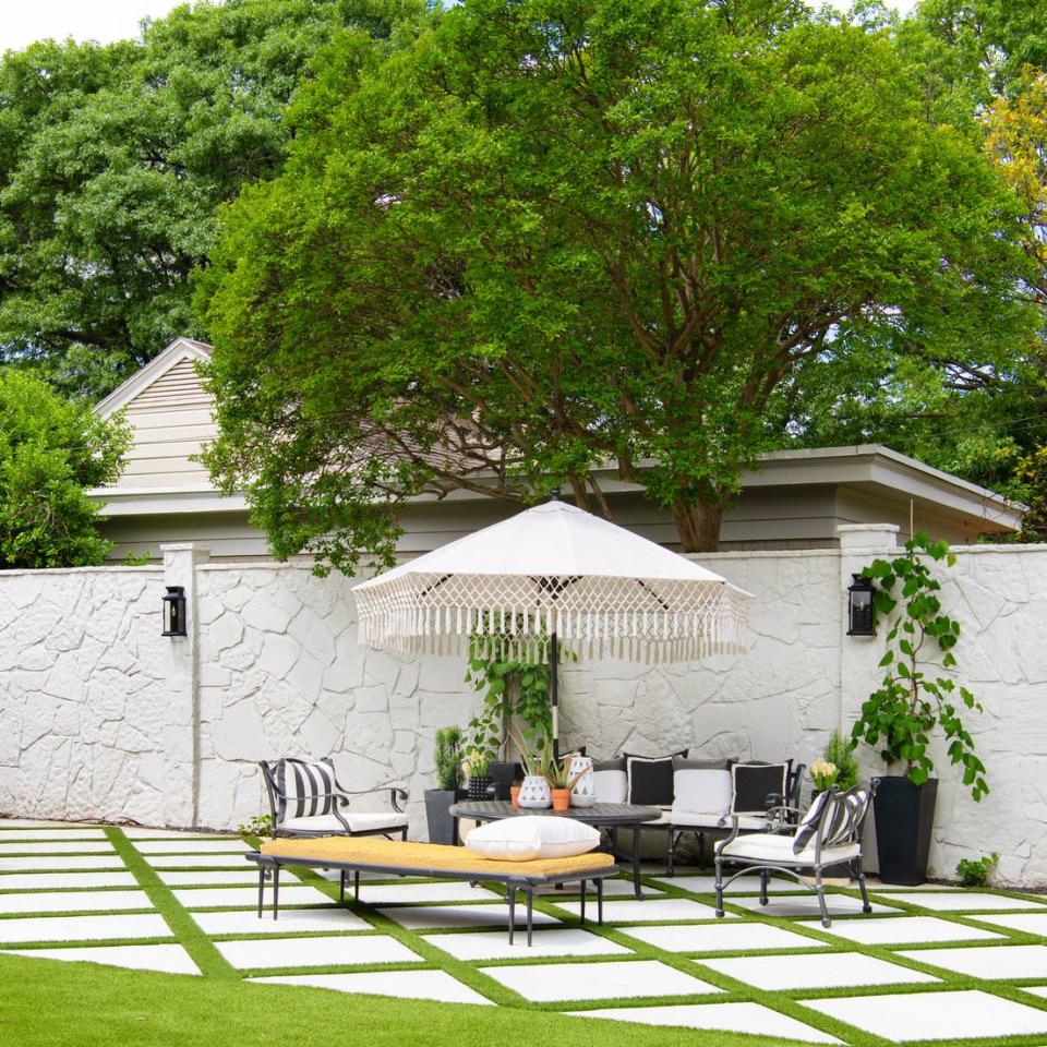 1930s cottage designed by burkle creative pergola patio anchoring the main entertaining space at the home of designer javier burkle, an ever changing mix of furnishings can work for cocktail hours or seated dinners the stone wall is a reference to the haciendas of mexico, burkle's home country paints greek villa, sherwin williams walls onyx black, glidden accents table ralph lauren home chairs cb2 rugs serena lily sofas one kings lane, in pindler sunbrella umbrella world market daybed cb2