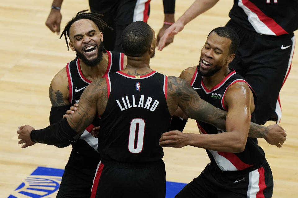 Portland Trail Blazers guard Damian Lillard (0) celebrates with guards Gary Trent Jr., left, and Rodney Hood after making the winning three-point basket during the second half of an NBA basketball game against the Chicago Bulls in Chicago, Saturday, Jan. 30, 2021. (AP Photo/Nam Y. Huh)
