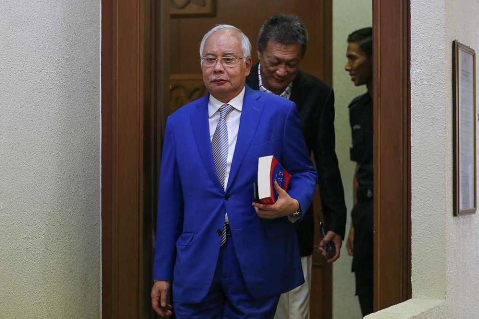 Datuk Seri Najib Razak seen here with the book 'The Laws of Human Nature' at the Kuala Lumpur court complex  June 13, 2019. — Picture by Yusof Mat Isa