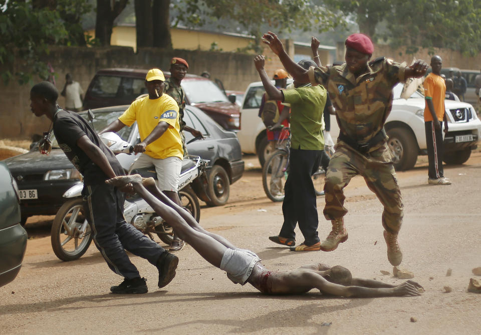 AP10thingsToSee - GRAPHIC CONTENT - Newly enlisted FACA (Central African Armed Forces) soldiers drag the body of a suspected Muslim Seleka militiaman moments after Central African Republic Interim President Catherine Samba-Panza addressed the troops in Bangui, Wednesday Feb. 5, 2014. The victim was lynched by hundreds of recruits and pelted with bricks and cut with knives. (AP Photo/Jerome Delay, File)