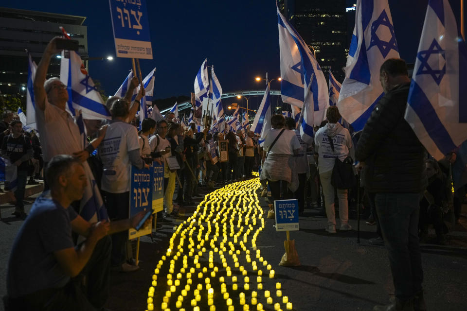 Israelis protest against plans by Prime Minister Benjamin Netanyahu's government to overhaul the judicial system, light candles in Tel Aviv, Israel, Saturday, April 22, 2023. (AP Photo/Tsafrir Abayov)