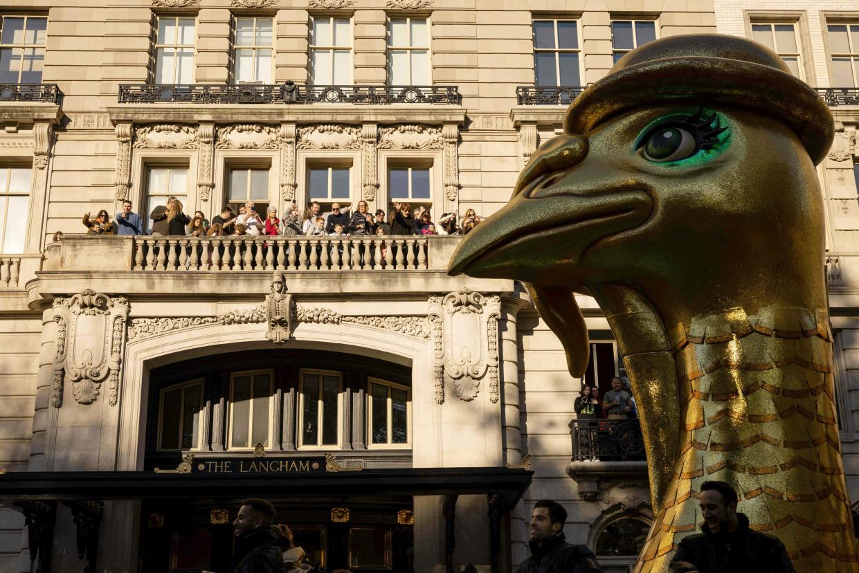 People gather on the balcony of the Langham hotel as floats pass.  (Yuki Iwamura / AFP - Getty Images)