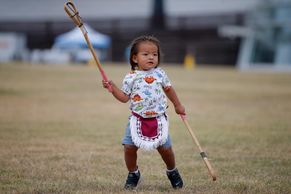 Rahikucu Frazier, 1, stands on the field before a stickball game during an Indigenous Peoples Day celebration Monday, Oct. 10, 2022, at the First Americans Museum.
