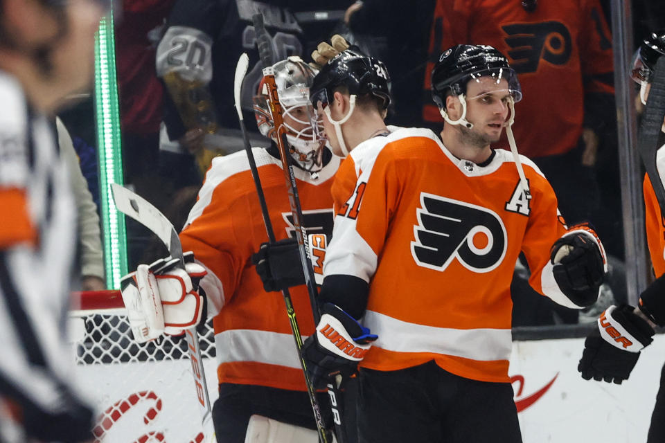 Philadelphia Flyers goalie Samuel Ersson, left, is congratulated by forward Scott Laughton, center after defeating the Los Angeles Kings in an NHL hockey game Saturday, Dec. 31, 2022, in Los Angeles. The Philadelphia Flyers won 4-2. (AP Photo/Ringo H.W. Chiu)