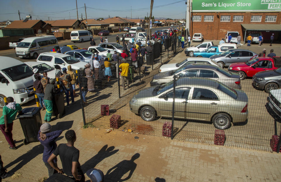 Customers queue to purchase alcoholic beverages outside the Sam Liquor Store in Thokoza township, near Johannesburg, South Africa, Monday, June 1, 2020. Liquor stores have reopened Monday after being closed for over two months under lockdown restrictions in a bid to prevent the spread of coronavirus. (AP Photo/Themba Hadebe)