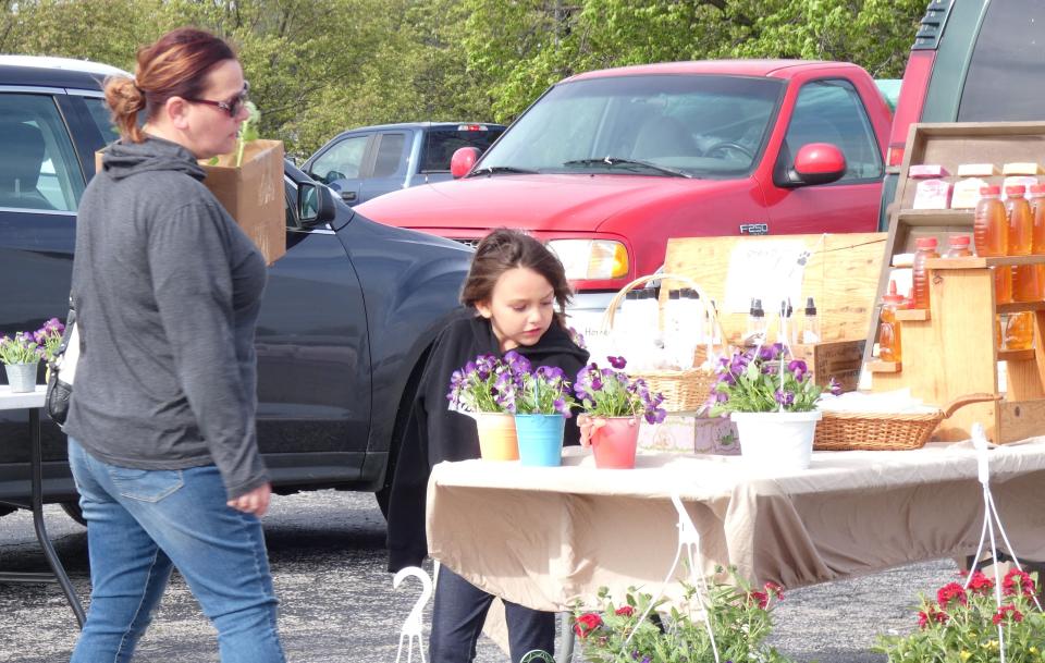 Shanna Sparks and her daughter Gracelynn Vasquez, 6, check out items for sale at the Bucyrus Farmers Market on Saturday morning.