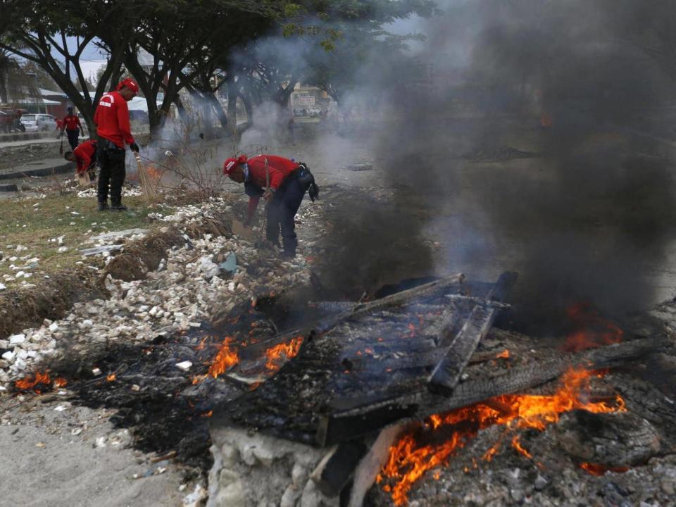 Rescuers burn debris (Associated Press)
