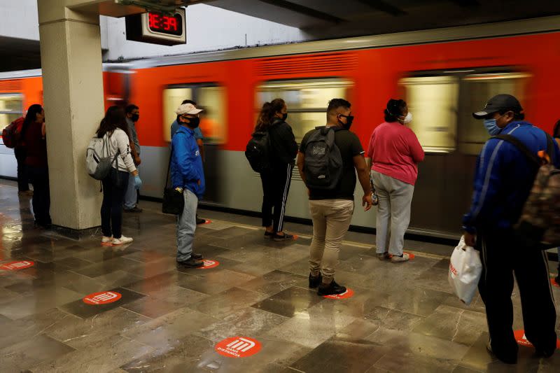 Commuters stand on social distance markers as they wait for the metro, as the government plans to start easing restrictions amid the outbreak of the coronavirus disease (COVID-19) in Mexico City